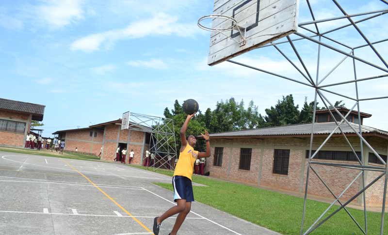 Ange proudly shows off her skills while shooting hoops in the SOS HG Secondary School basketball court in Bujumbura.