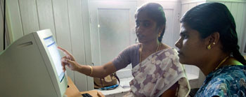 Girl teaching how to use a computer in Nagapattinam, India