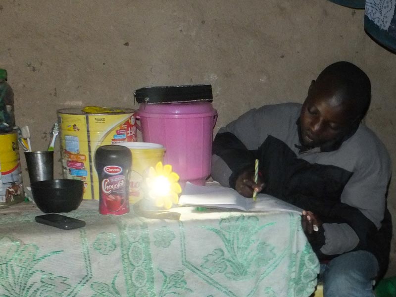 Noel's daughter doing homework by sun light