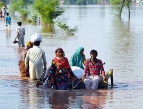 Les gens marchant à travers les hautes eaux au Pakistan Inondation