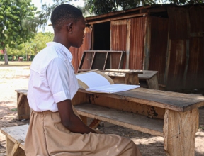 Togo-Atakpame-Adjoua-in-school-uniform-reading_600