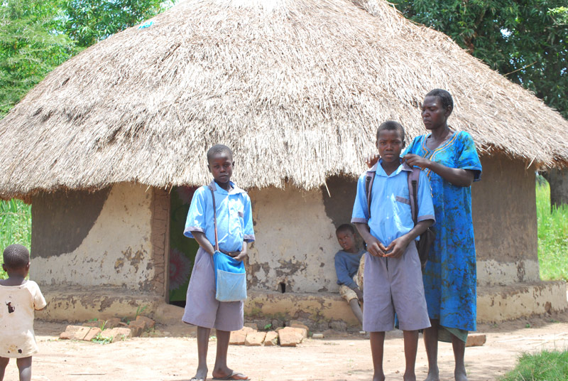 Timothy has his school uniform collar fixed by his aunt in Gulu, Uganda